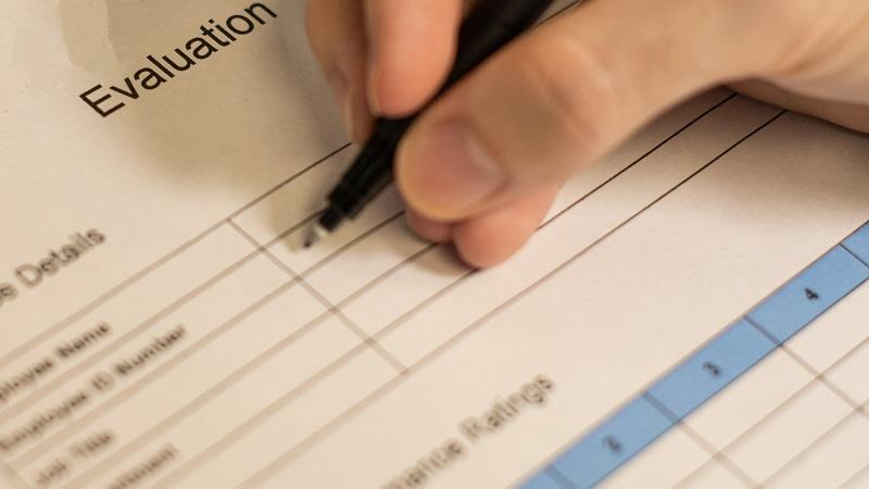 A close-up image of someone filling out a form marked &#039;Evaluation&#039;