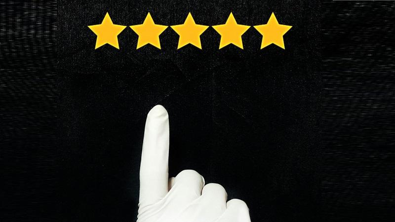 An image of a gloved hand pointing up towards a five-star rating