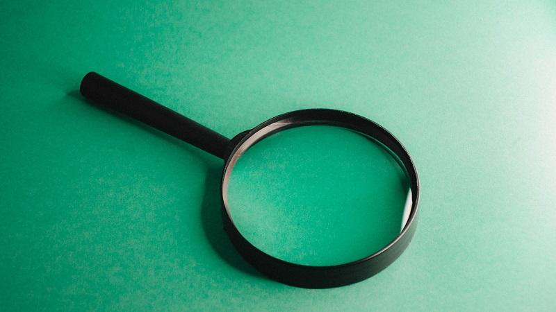 An image of a magnifying glass on a green background