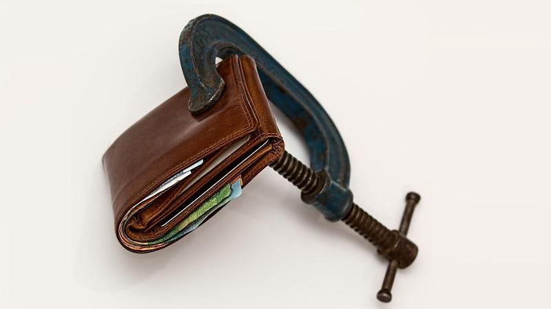 An image of a wallet gripped in a vice