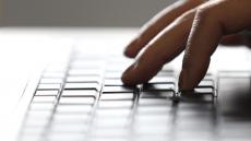 A close-up image of someone typing on a laptop keyboard