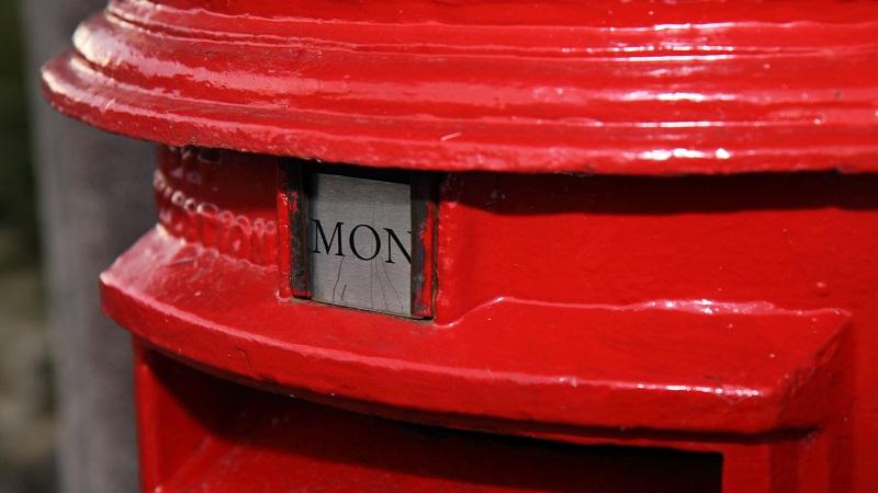 A close-up image of a post box with a sign indicating the next collection will be on Monday