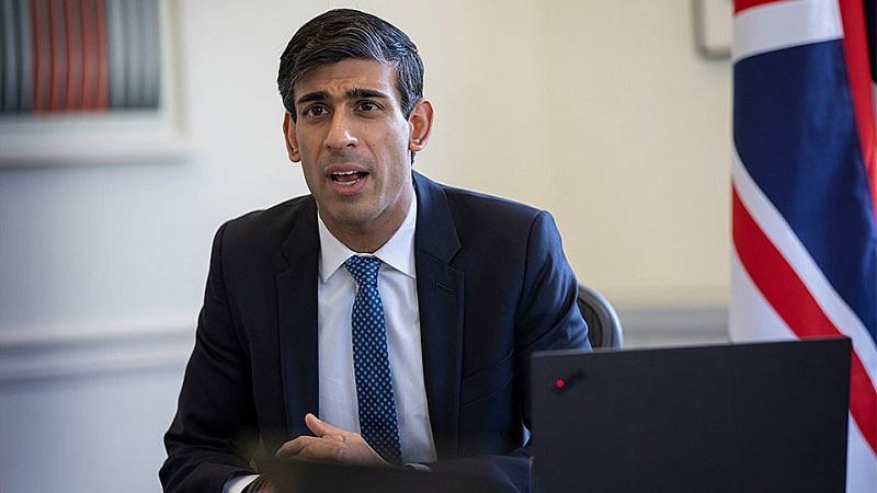 Rishi Sunak pictured with Union flag and computer