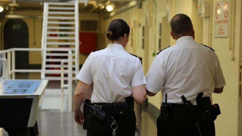 An image of two prison officers walking along a corridor