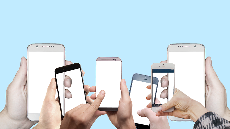 An image of hands holding up a range of smartphone handsets with blank screens